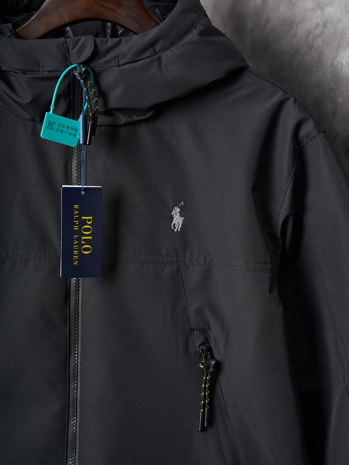 P980 Actual auction】Ralph Lauren/Ralph Lauren pony embroidered zipper hooded down jacket [Ready stock] S M L XL high-quality filling: 90 white duck down is selected, weighing 220g, ensuring excellent thermal insulation performance. After strict screening and processing, the velvet is not easy to be drilled, ensuring durability. The density of high-density nylon taffeta is about 210T-300T, with a smooth and slightly matte surface, excellent windproof and waterproof properties (with DWR water-repellent treatment), strong wrinkle resistance and easy care, in line with the positioning of American casual "durable and practical".  The inner lining is made of 100% polyamide. The high-density and tight weaving process prevents fine lint from getting out of the gaps in the fabric. The smooth surface improves the putting on and taking off experience, and the excellent wear and tear resistance ensures damage caused by frequent use, while the light and soft texture does not affect the overall weight.  The classic jacket has a slightly loose fit, slightly dropped shoulder line (shoulder width is 1-2cm wider than the standard fit), is hip-length, and has slightly tapered straight sleeves, taking into account both freedom of movement and casual style.  The adjustable Velcro on the cuffs allows you to freely adjust the tightness according to the thickness of your wrist and personal preferences, effectively preventing cold wind from intruding, and improving the warmth performance.  In terms of storage, the two front zipper pockets are convenient for you to place frequently used items, and the zipper design ensures that items are not easily lost. A built-in pocket on the left side of the chest provides a safe storage space for some small private items.  The drawstring design at the hem allows you to adjust the shape of the jacket according to your body shape and dressing needs. Whether it is loose and casual or slim and neat, you can easily control it.  Embroidery technology: Polo horse logo on the left chest: flat satin stitch embroidery (satin embroidery), embroidery thread: 100% polyester high color fastness embroidery thread (the color number is consistent with the brand’s standard red color card), stitch density 12-15 stitches/cm, the outline of the horse logo is clear, and the details of the rider and horse are burr-free.  Embroidery positioning: precise positioning through the template (12cm from the neckline and 8cm from the placket) to ensure left and right symmetry and centering.